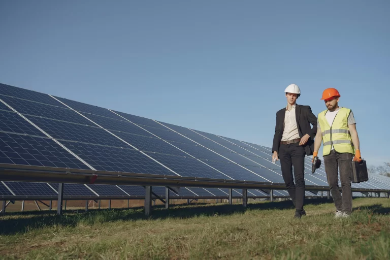 Ingenieros inspeccionando un campo de paneles solares.